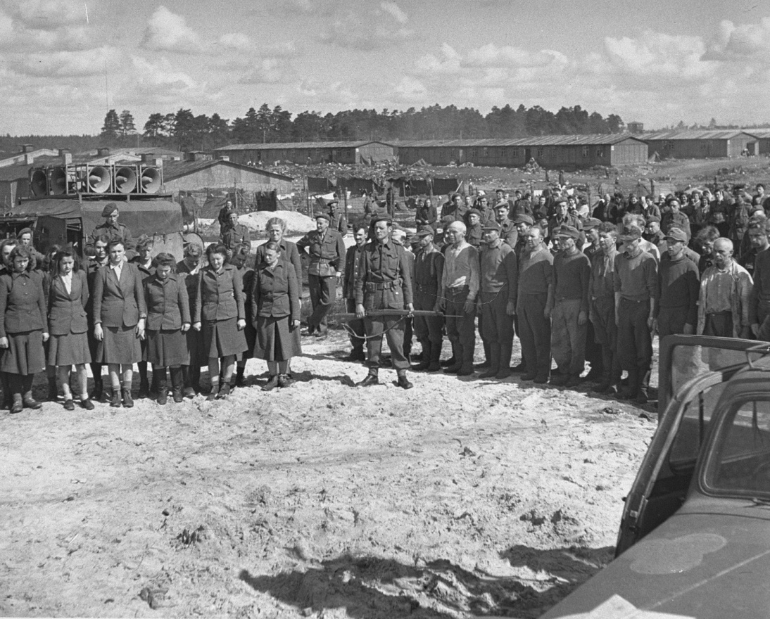 SS officers and guards lined up in front of one of the mass graves. The British had them bury the 10,000 bodies found at Bergen-Belsen. After liberation, another 13,800 prisoners died, mostly of typhus (US Holocaust Memorial Museum)